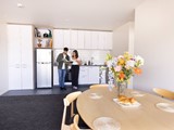 Couple having coffee and reading a recipe book in a Te Kainga apartment kitchen